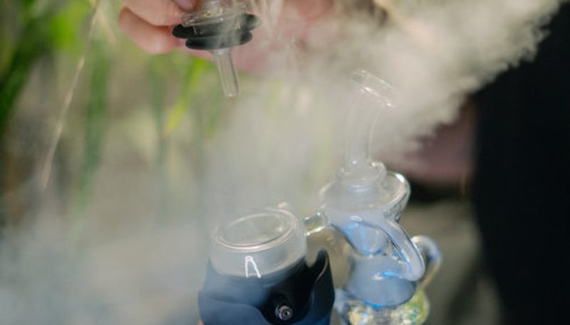 เครื่อง Vaporizer ยอดนิยมวางเรียงบนโต๊ะ ได้แก่ Dynavap สีเงินรูปทรงปากกา Arizer Solo 3 สีดำขนาดใหญ่ และ Mighty+ สีเทา จากซ้ายไปขวา แสดงความแตกต่างของขนาดและดีไซน์